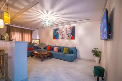a living room with a blue couch and a tv at Les cristaux de Marrakech in Marrakech