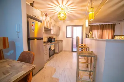 a kitchen with a refrigerator and a table with chairs at Les cristaux de Marrakech in Marrakech