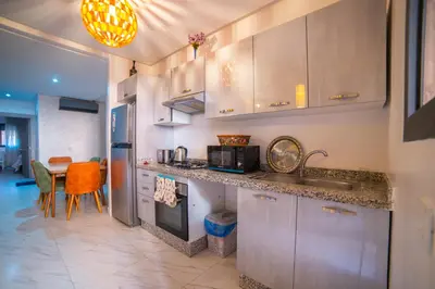 a kitchen with a sink and a table in it at Les cristaux de Marrakech in Marrakech