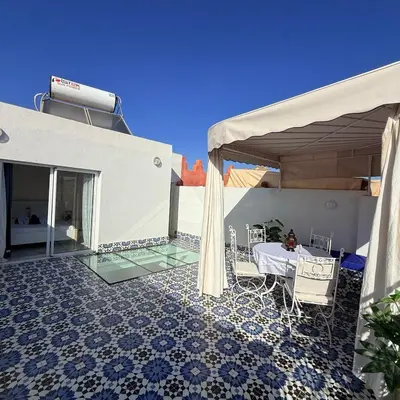 a house with a patio with a table and chairs at White Riad Residence in Oulad Akkou