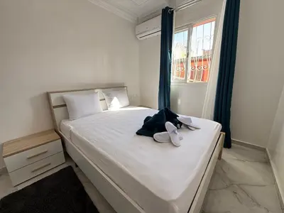 a bedroom with a bed with shoes on it at White Riad Residence in Oulad Akkou