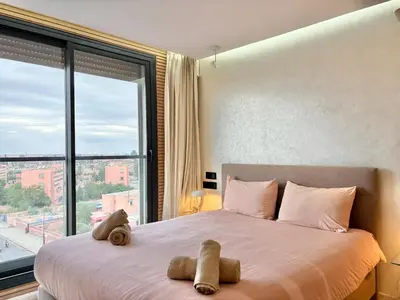 a bedroom with a large bed with two stuffed animals on it at Verona Studio - 1 Bedroom Piscine & Rooftop in Marrakech