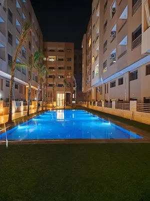 an empty swimming pool in a building at night at Appartement a Menara garden in Marrakech