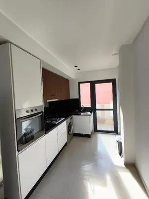 a kitchen with white appliances and a large window at Appartement a Menara garden in Marrakech