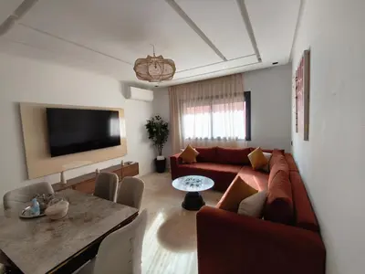 a living room with a couch and a table at Appartement a Menara garden in Marrakech