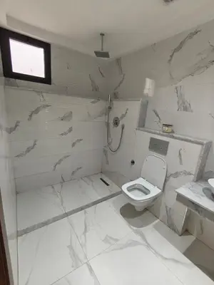 a white bathroom with a toilet and a sink at Appartement a Menara garden in Marrakech