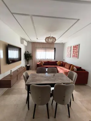 a living room with a table and a couch at Appartement a Menara garden in Marrakech