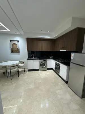 a kitchen with a table and a dishwasher and a kitchen with a table at Studio a Menara garden in Marrakech