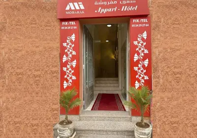 an entrance to a hotel with two palm trees in a hallway at Appart Mobarak 5 in Marrakech