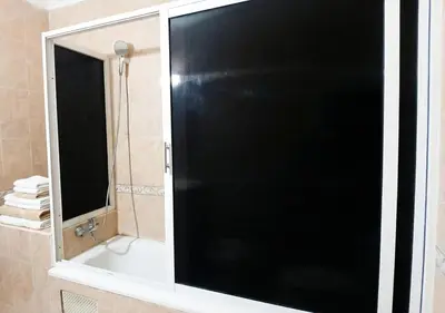 a black shower door in a bathroom with a mirror at Appart Mobarak 5 in Marrakech