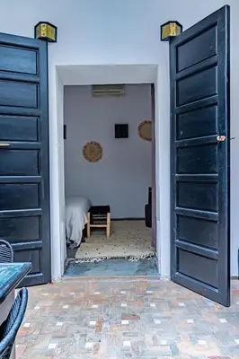 a room with two black doors and a bed at Maison Meurisse Tlata private and Daily Breakfast in Marrakech