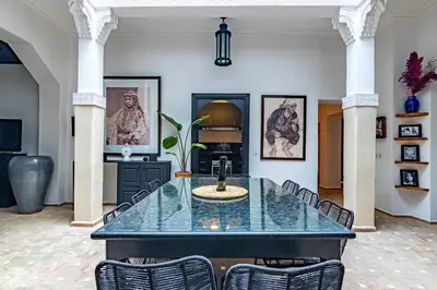 a dining room with a glass table and chairs at Maison Meurisse Tlata private and Daily Breakfast in Marrakech