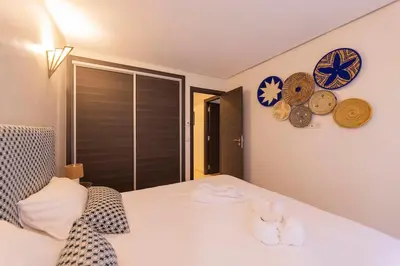 a bedroom with a bed with clocks on the wall at Sublime appartement 2 chambres en plein centre entre Gueliz et hivernage avec piscine in Marrakech