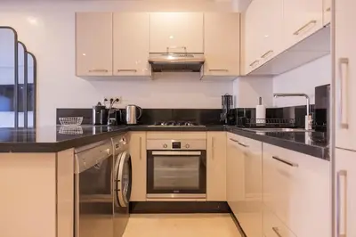a kitchen with white cabinets and stainless steel appliances at Sublime appartement 2 chambres en plein centre entre Gueliz et hivernage avec piscine in Marrakech