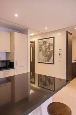 a kitchen with a picture of two people on the wall at Sublime appartement 2 chambres en plein centre entre Gueliz et hivernage avec piscine in Marrakech