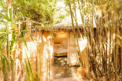 a small house with a bed in a forest at Oasis Garden Marrakech in Marrakech