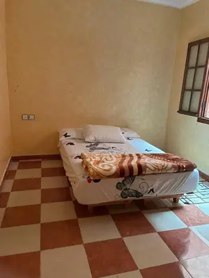 a bed in a room with a checkered floor at Appartement meublé calme près de l'aéroport menara in Marrakech