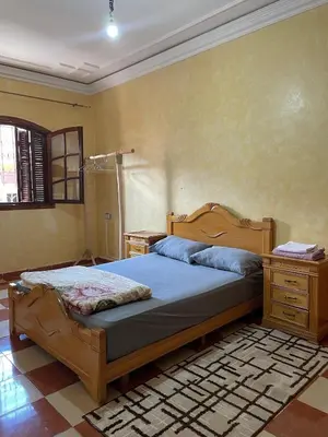 a bedroom with a bed with a wooden frame and a dresser at Appartement meublé calme près de l'aéroport menara in Marrakech