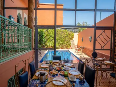 a dining room with a table and a pool at Hôtel Boutique RAM SPA in Marrakech