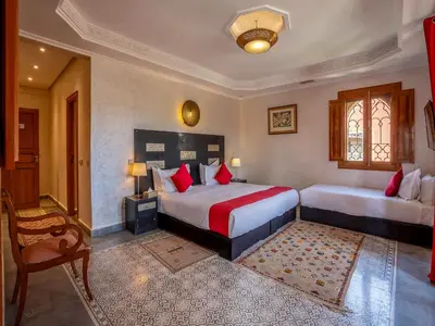 a bedroom with two beds with red pillows at Hôtel Boutique RAM SPA in Marrakech