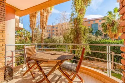 a patio with a table and chairs on a balcony at Bright & Cozy Appt with Exclusive Private terrace in Marrakech