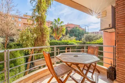 a patio with a table and chairs on a balcony at Bright & Cozy Appt with Exclusive Private terrace in Marrakech