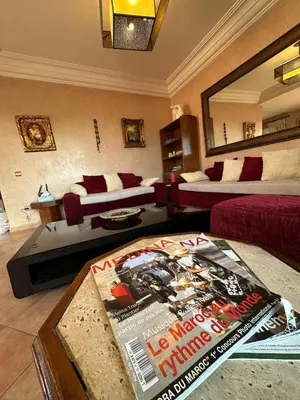 a living room with two beds and a magazine at Appartement avec piscine Vue colline à Gueliz in Marrakech