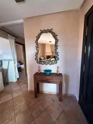 a mirror on a wall with a table in a room at Appartement avec piscine Vue colline à Gueliz in Marrakech