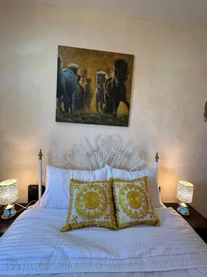 a bedroom with a white bed with a painting on the wall at Appartement avec piscine Vue colline à Gueliz in Marrakech