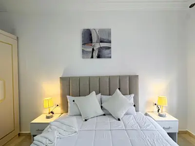 a bedroom with a white bed with two lamps at L'Havre de Paix 2 in Marrakech