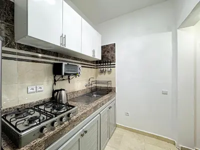 a kitchen with a stove and white cabinets at L'Havre de Paix 2 in Marrakech
