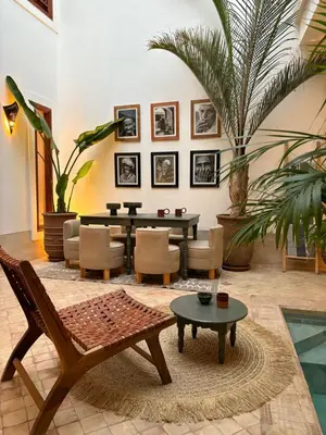 a living room with a table and chairs at Riad melqa piscine privée - Medina Marrakech in Marrakech