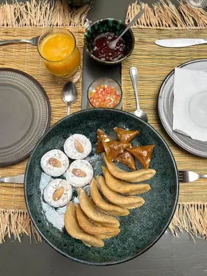 a plate of food with eggs and bananas on a table at Riad melqa piscine privée - Medina Marrakech in Marrakech