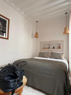 a bedroom with a bed with a black bag on it at Riad melqa piscine privée - Medina Marrakech in Marrakech