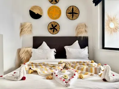 a bedroom with a bed with clocks on the wall at Maison Meurisse Sta'a private pool breakfast in Marrakech