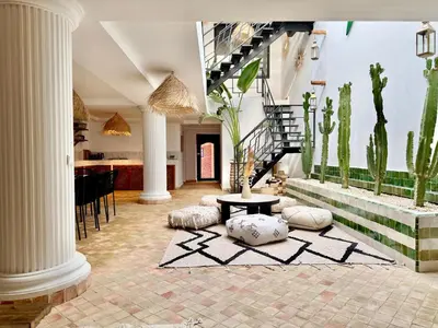 a living room with a staircase and cactus at Maison Meurisse Sta'a private pool breakfast in Marrakech