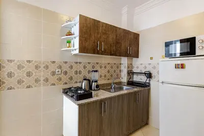 a small kitchen with a sink and a refrigerator at Spacious Can 2025 Iptv Guéliz 7 min away in Marrakech
