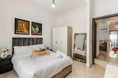 a bedroom with a large bed with a table on it at Spacious Can 2025 Iptv Guéliz 7 min away in Marrakech