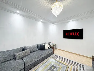 a living room with a couch and a tv at Urban Cocoon Quiet and modern in Marrakech