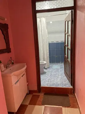 a bathroom with a sink and a toilet and a door at Appartement proche de l'airoport in Marrakech