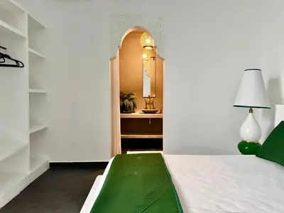 a bedroom with a bed with a green blanket on it at Riad Florival breakfast private kasbah in Marrakech