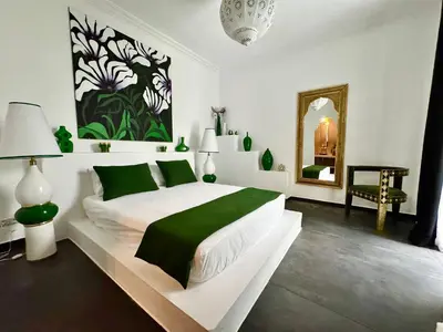 a bedroom with a large bed and a mirror at Riad Florival breakfast private kasbah in Marrakech