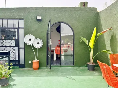 a green wall with a door with a surfboard on it at Riad Florival breakfast private kasbah in Marrakech