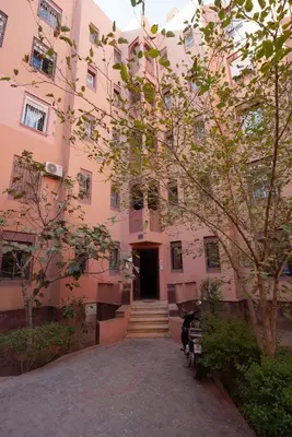 a pink building with a tree in front of it at Maison M, Spacious 2-Bedroom Apartment in Marrakech in Marrakech