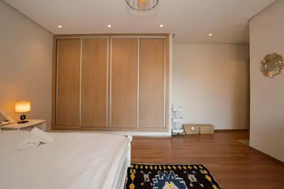a bedroom with a bed with a large wooden cabinet at Maison M, Spacious 2-Bedroom Apartment in Marrakech in Marrakech