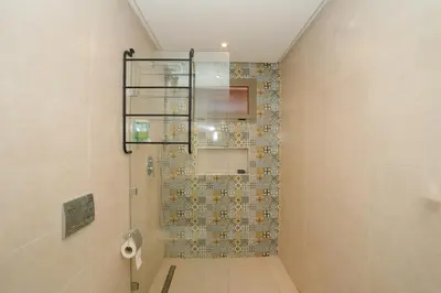 a bathroom with a shower with a tiled wall at Maison M, Spacious 2-Bedroom Apartment in Marrakech in Marrakech