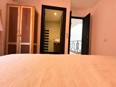a bedroom with a bed and a door to a bathroom at Maison Meurisse KHAMSaPrivate pool and breakfast in Marrakech