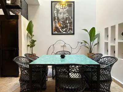 a dining room with a green table and chairs at Maison Meurisse KHAMSaPrivate pool and breakfast in Marrakech