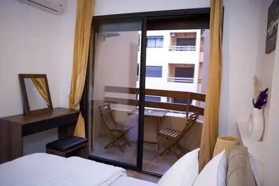 a bedroom with a bed and a desk and a balcony at Le Loft Chic Hivernage Piscine & Parking Privé in Marrakech