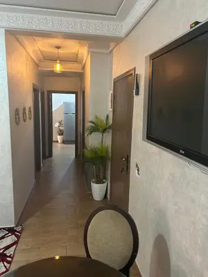 a hallway with a flat screen tv on a wall at Appt á louer TF2 in Marrakech